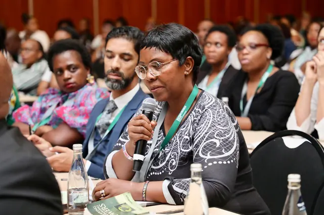 An attendee asking a question into a microphone from the audience